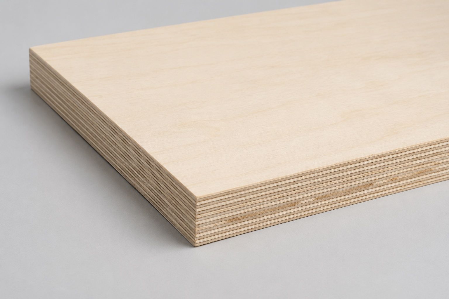 Stapel von hellen Sperrholzplatten auf grauer Oberfläche