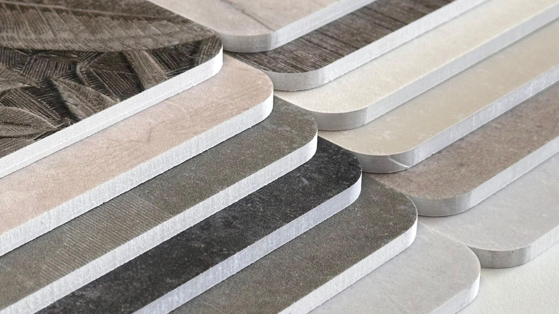 Nahaufnahme von zwei Stapeln hellfarbiger Sperrholzplatten, die den geschichteten Aufbau des Materials zeigt.