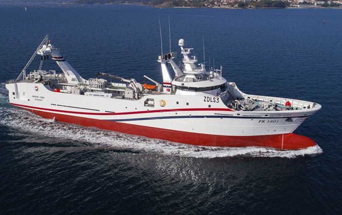 Un gran barco blanco y rojo flota sobre un cuerpo de agua.