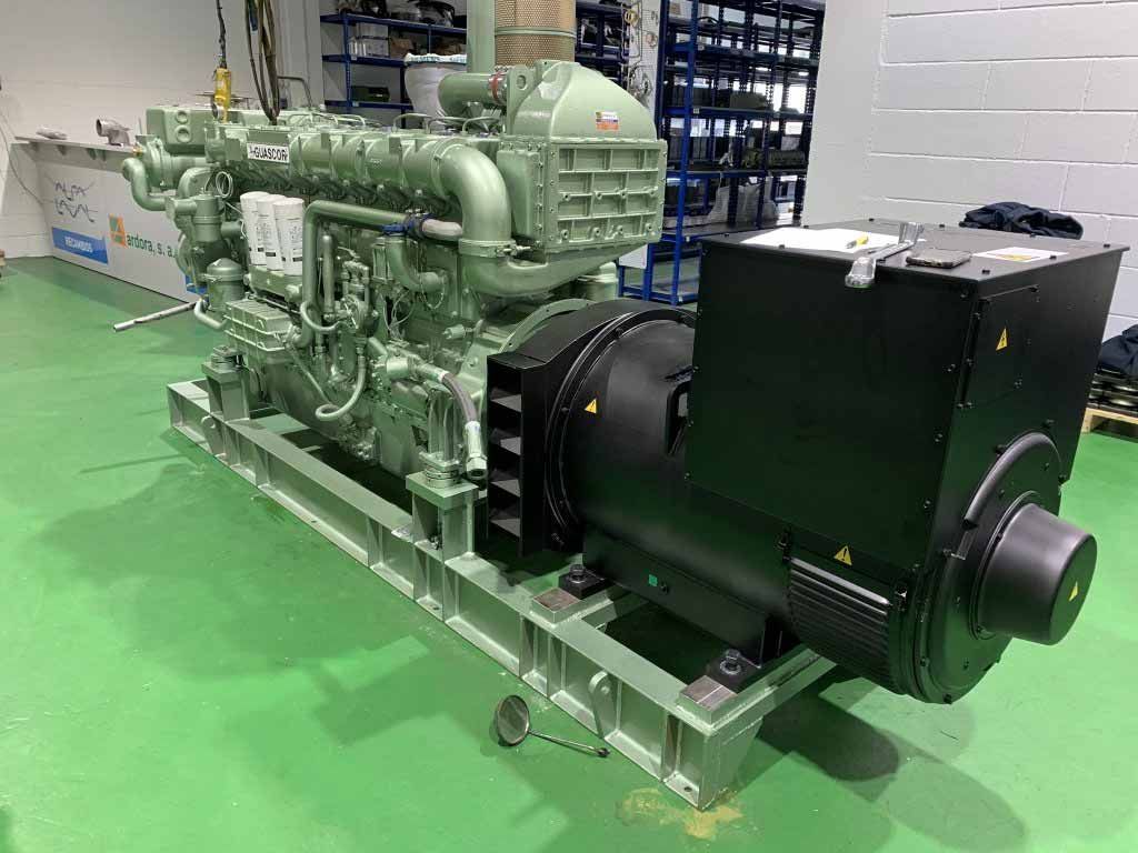 Un gran generador diésel se encuentra sobre un suelo verde en un almacén.