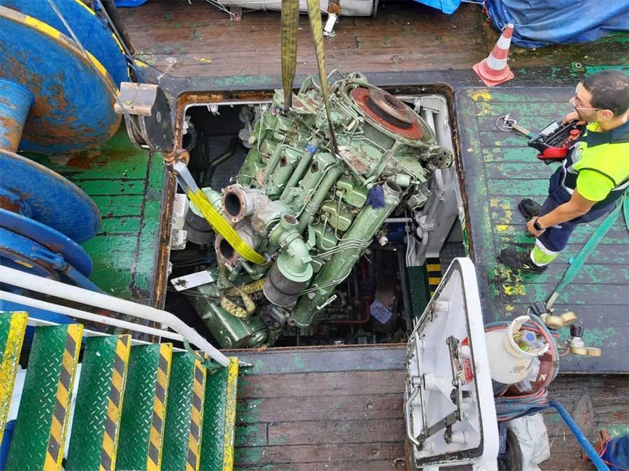 Un hombre está trabajando en un motor grande en un barco.