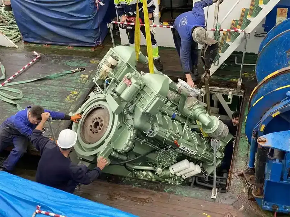 Un grupo de hombres está trabajando en un motor grande en un barco.