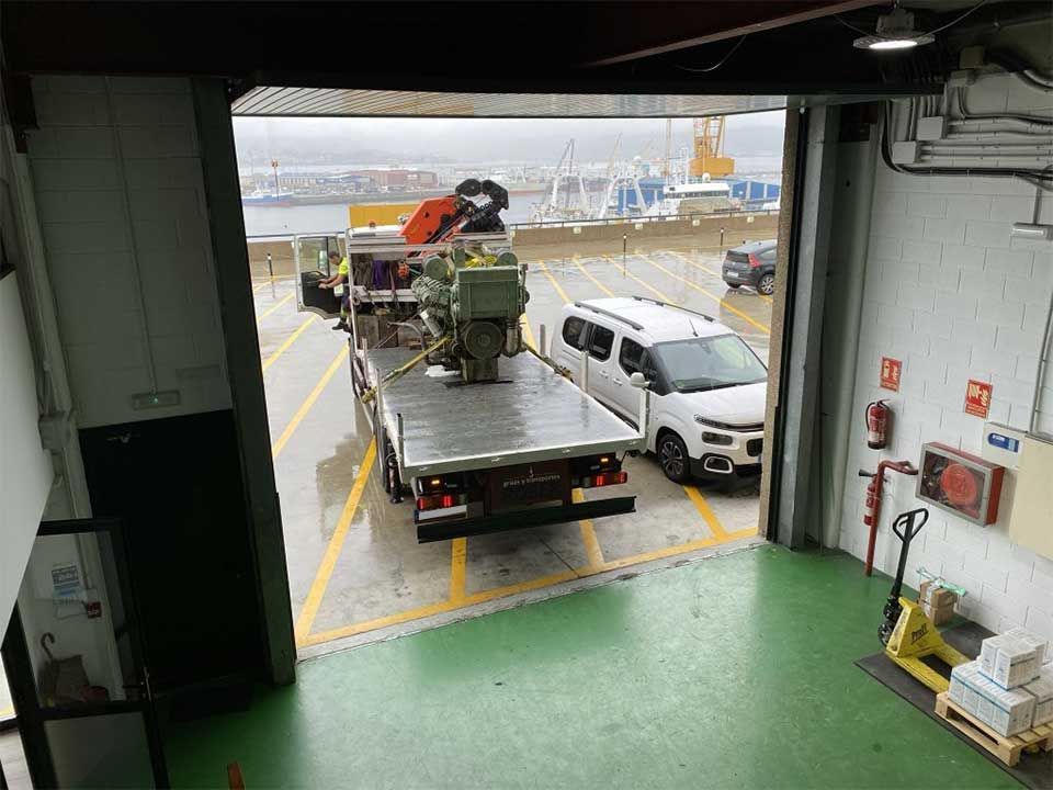 Un camión con una grúa en la parte trasera está estacionado en un garaje.