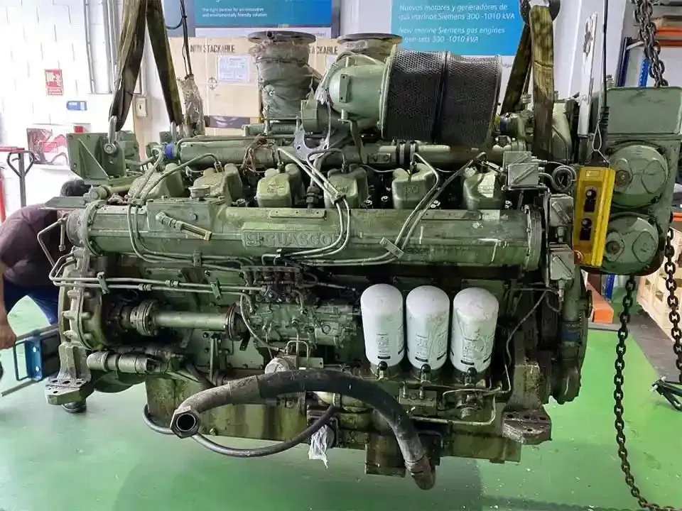 Un hombre está trabajando en un motor grande en una fábrica.