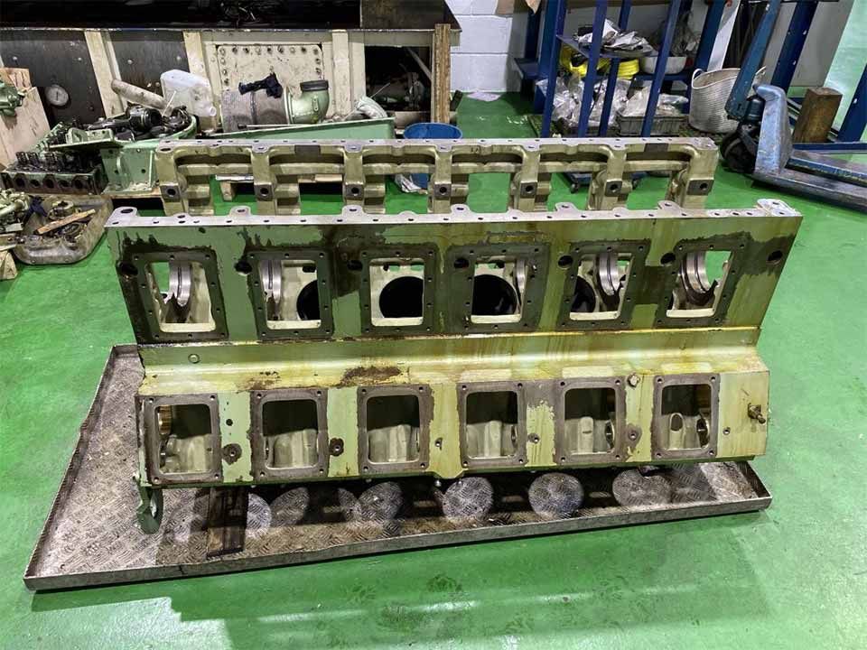 Un trozo de metal reposa sobre una bandeja sobre un suelo verde.