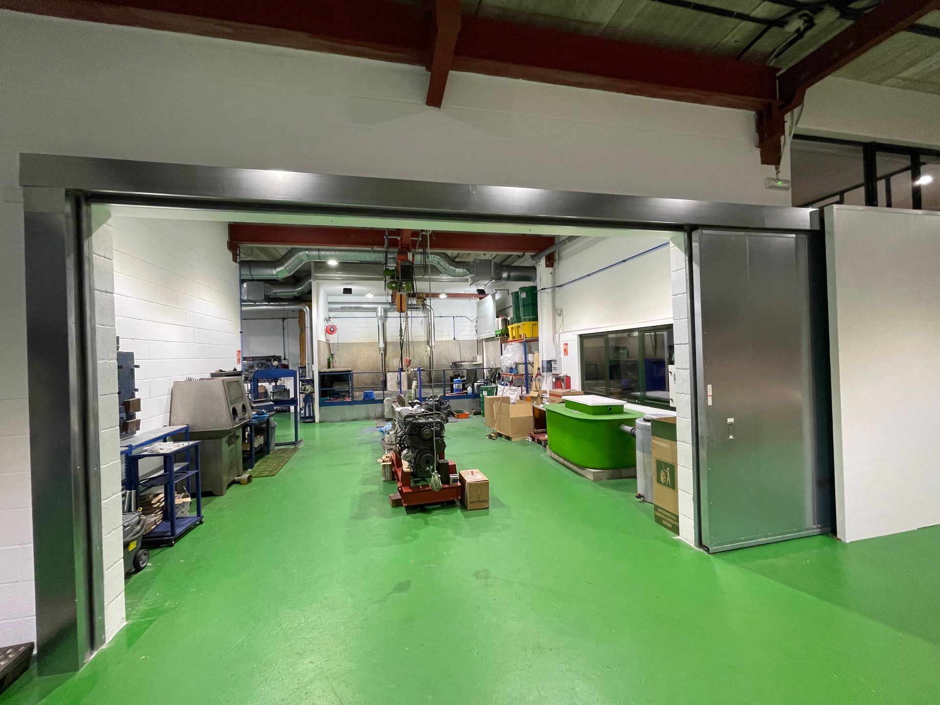 Un gran almacén con suelo verde y puerta corrediza.