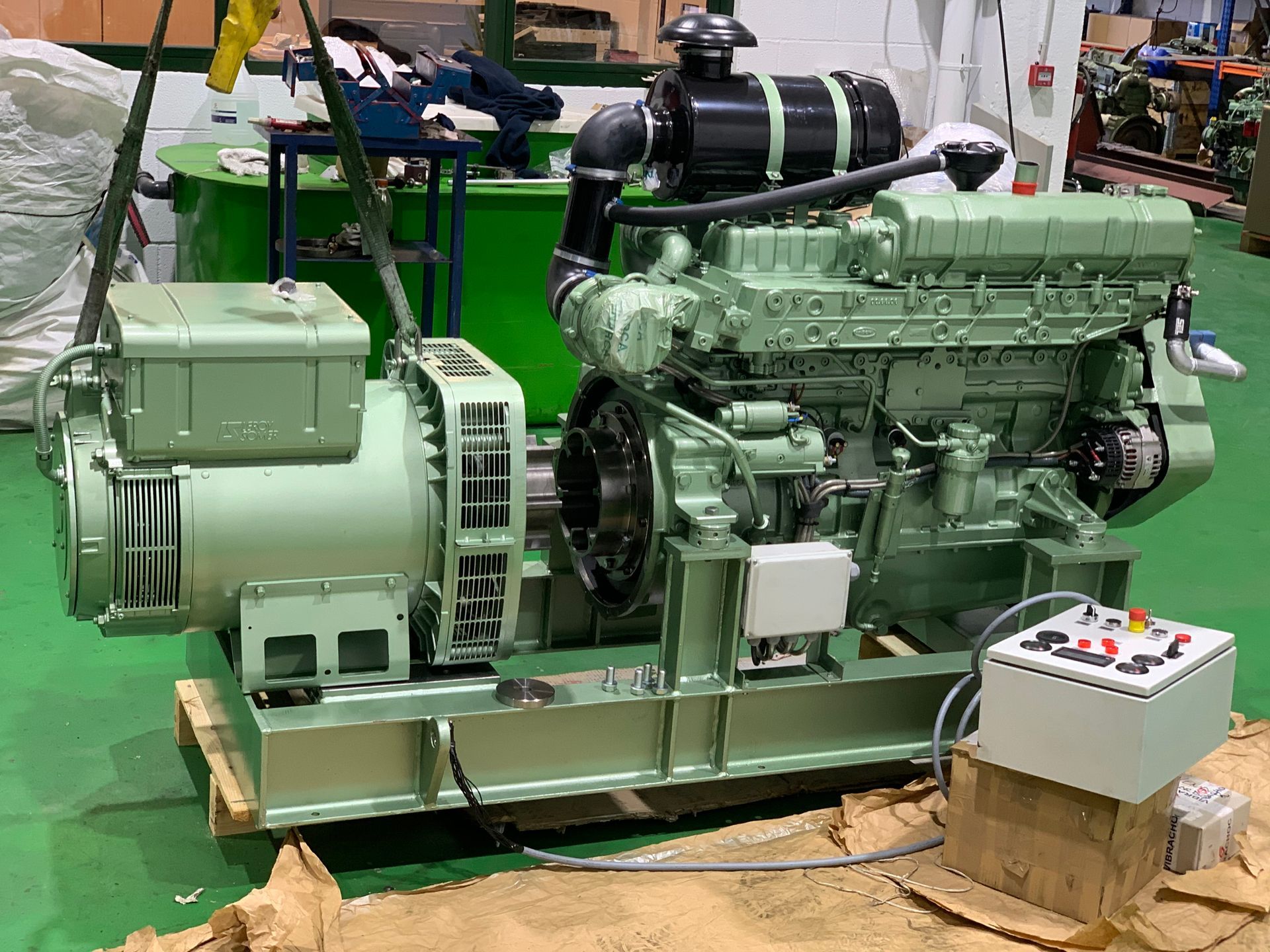 Un motor diésel está colocado encima de un palé de madera en una fábrica.