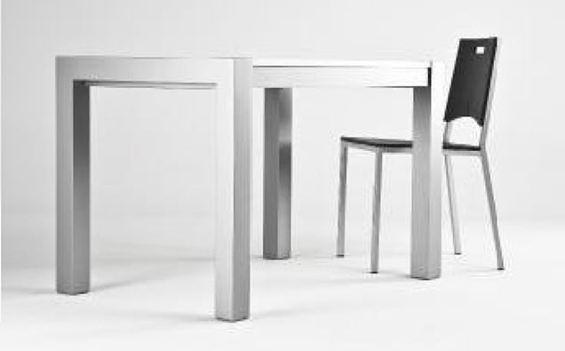 Mesa blanca minimalista y dos sillas sobre un fondo liso y claro