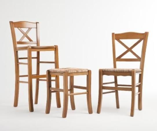 Tres sillas de madera clara y una mesita a juego sobre un fondo blanco