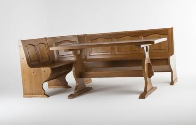 Mesa de madera de estilo antiguo, con patas y paneles laterales tallados, sobre fondo blanco