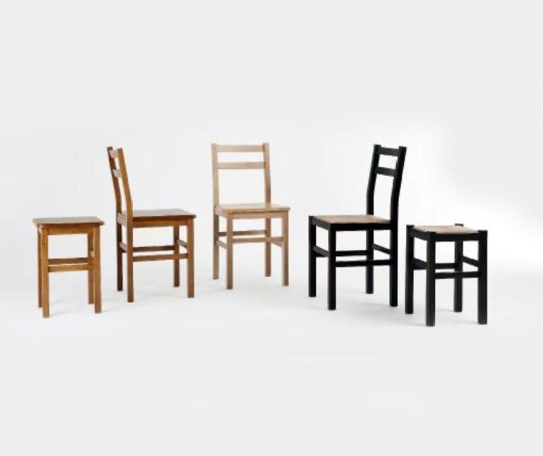 Cinco sillas y taburetes de madera con distintos acabados, dispuestos en fila sobre un fondo blanco