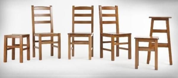 Sillas de madera variadas, de distintos estilos, dispuestas en fila sobre un fondo blanco