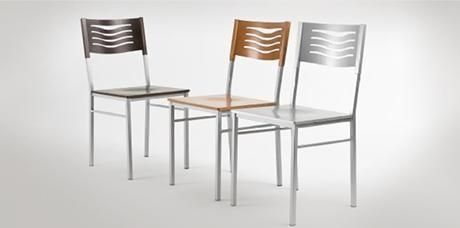 Tres sillas de comedor modernas en negro, madera y blanco sobre un fondo gris claro