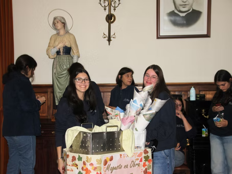 Em uma sala que lembrava uma igreja, pessoas se reuniram em volta de uma caixa de doações, com uma estátua e um retrato emoldurado na parede.