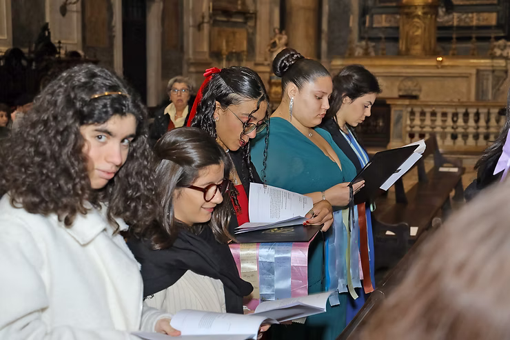 Pessoas lendo folhetos no interior de uma grande igreja.