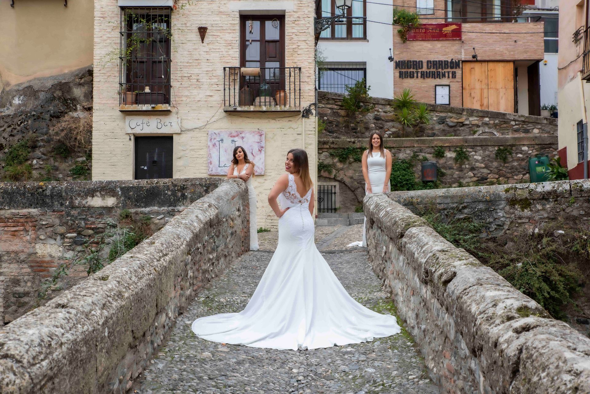 Una mujer con un vestido de novia está parada en un puente.