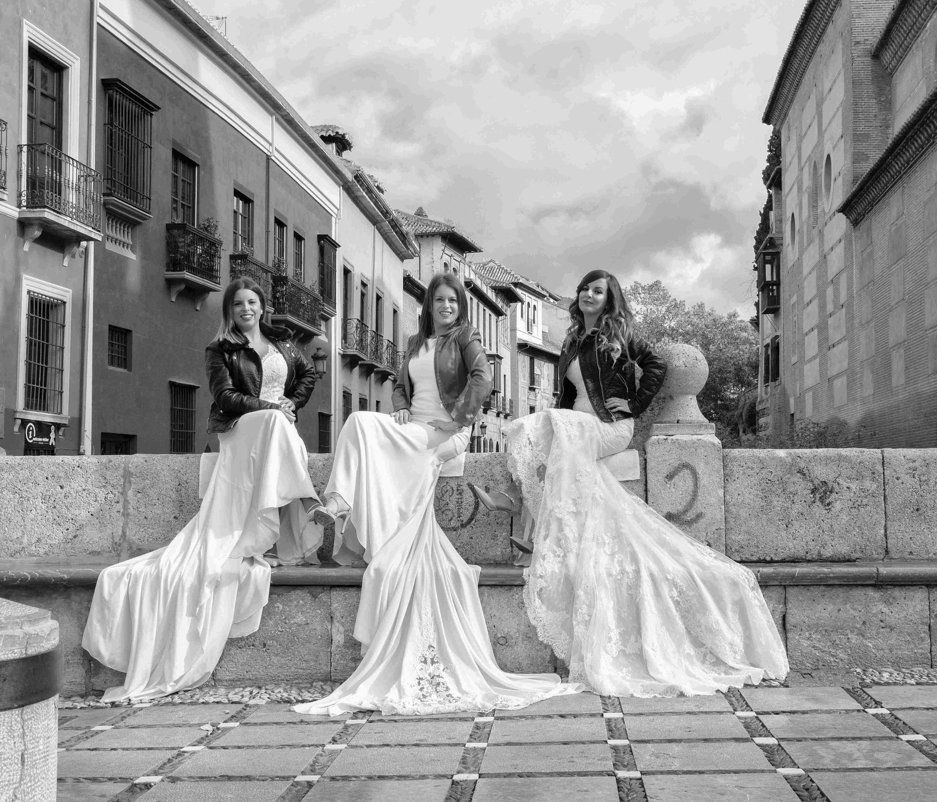 Una fotografía en blanco y negro de cuatro mujeres con vestidos blancos largos.