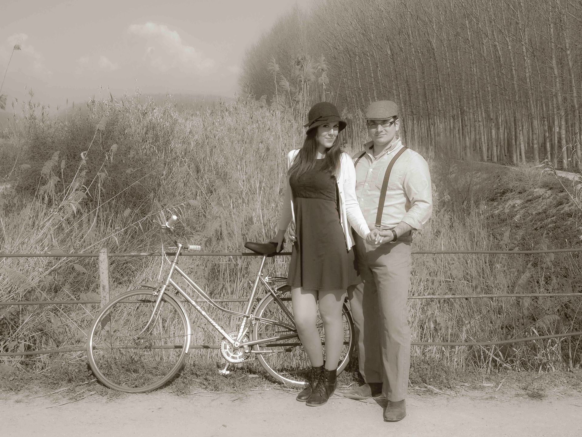 Un hombre y una mujer están de pie junto a una bicicleta.