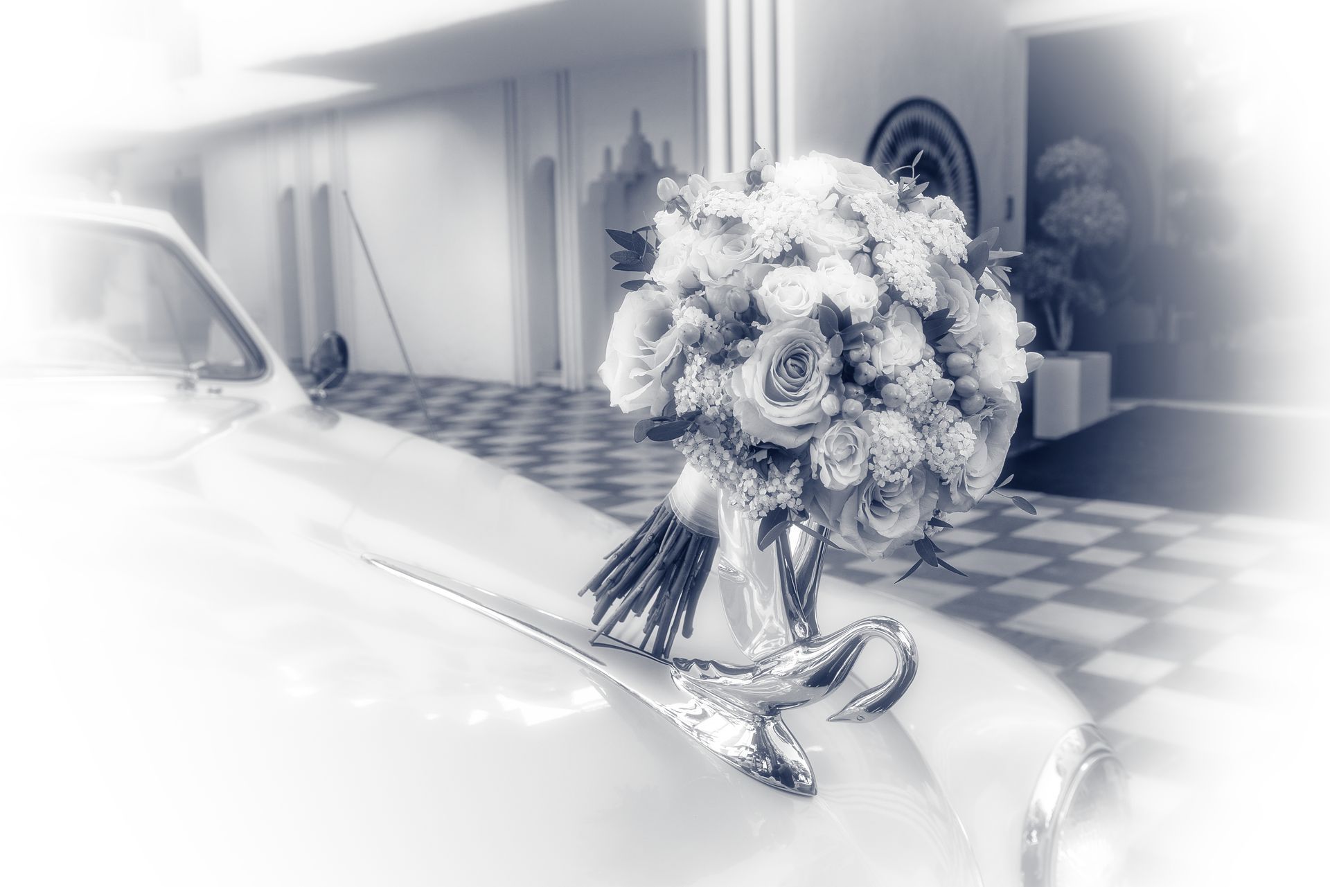 Un coche blanco con un ramo de flores en el capó.