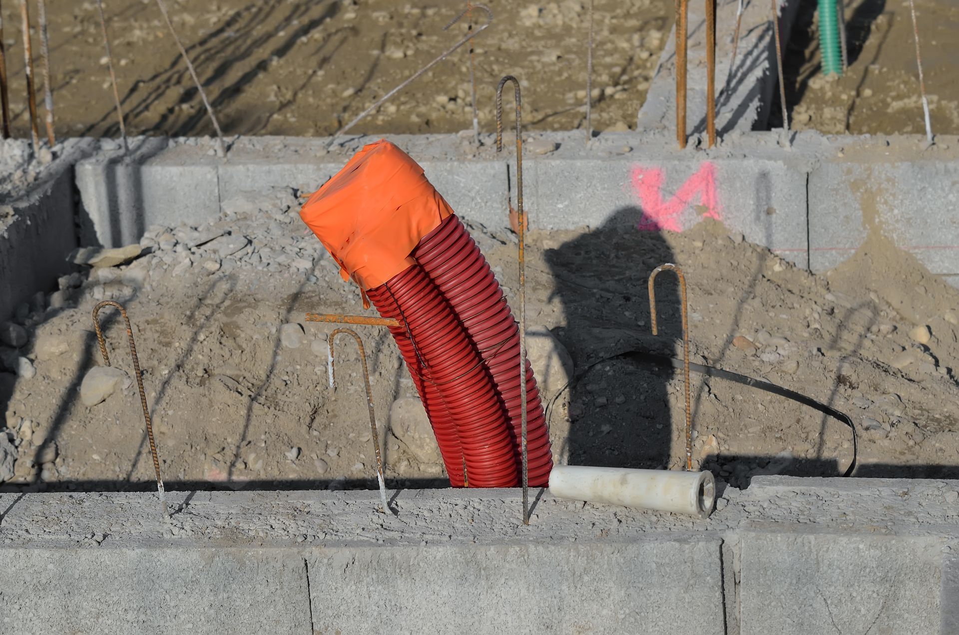 Conduit ondulé dépassant d'une fondation en béton en construction.