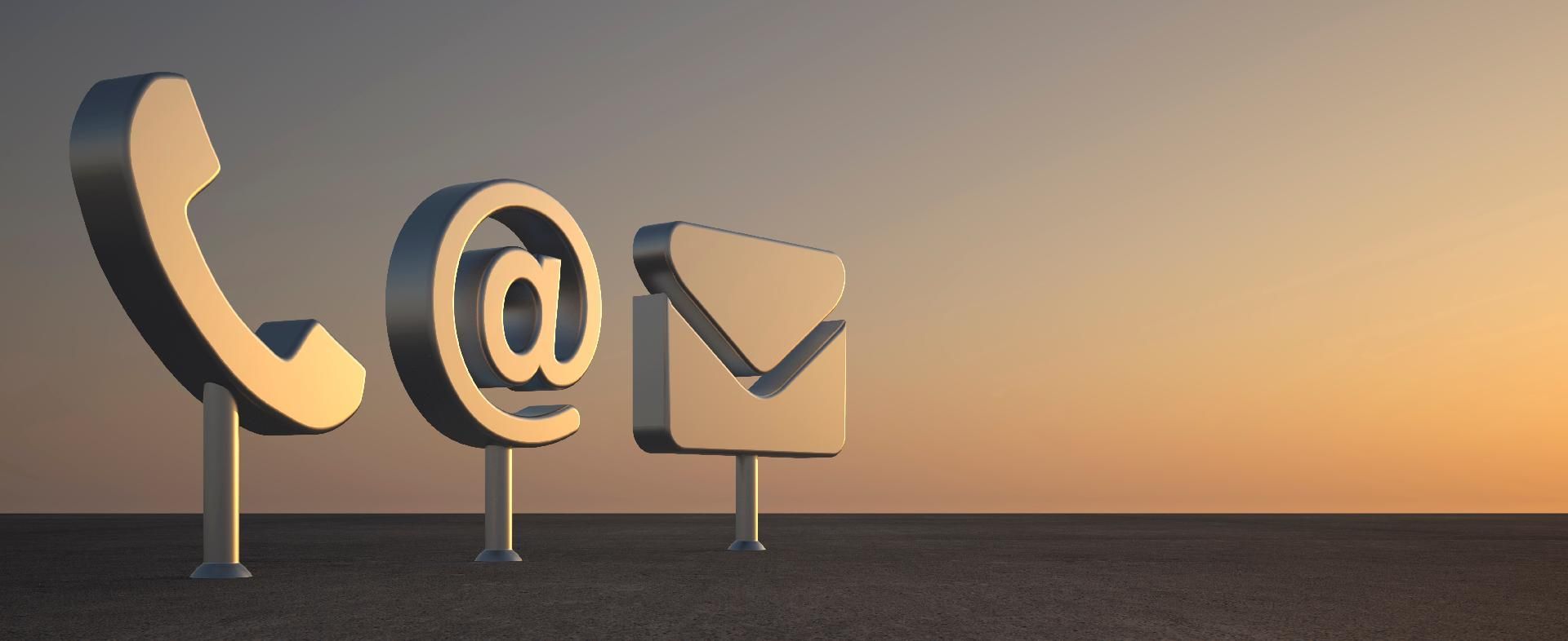 Telefon-, E-Mail- und @-Symbole stehen im warmen orangefarbenen Licht eines Sonnenuntergangs.