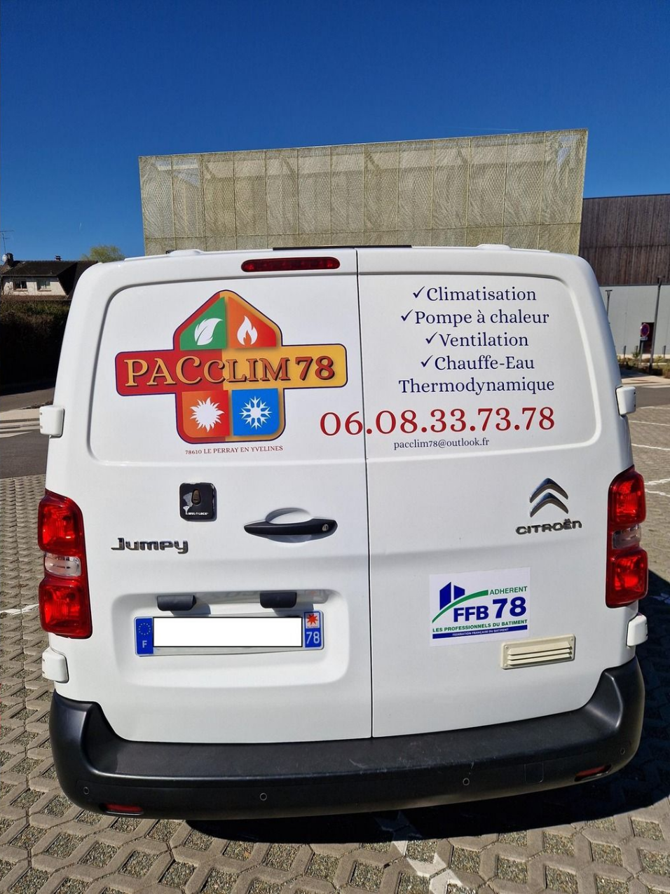 Fourgonnette Citroën blanche avec le logo PACCLIM78, le numéro de téléphone et la liste des services au dos.