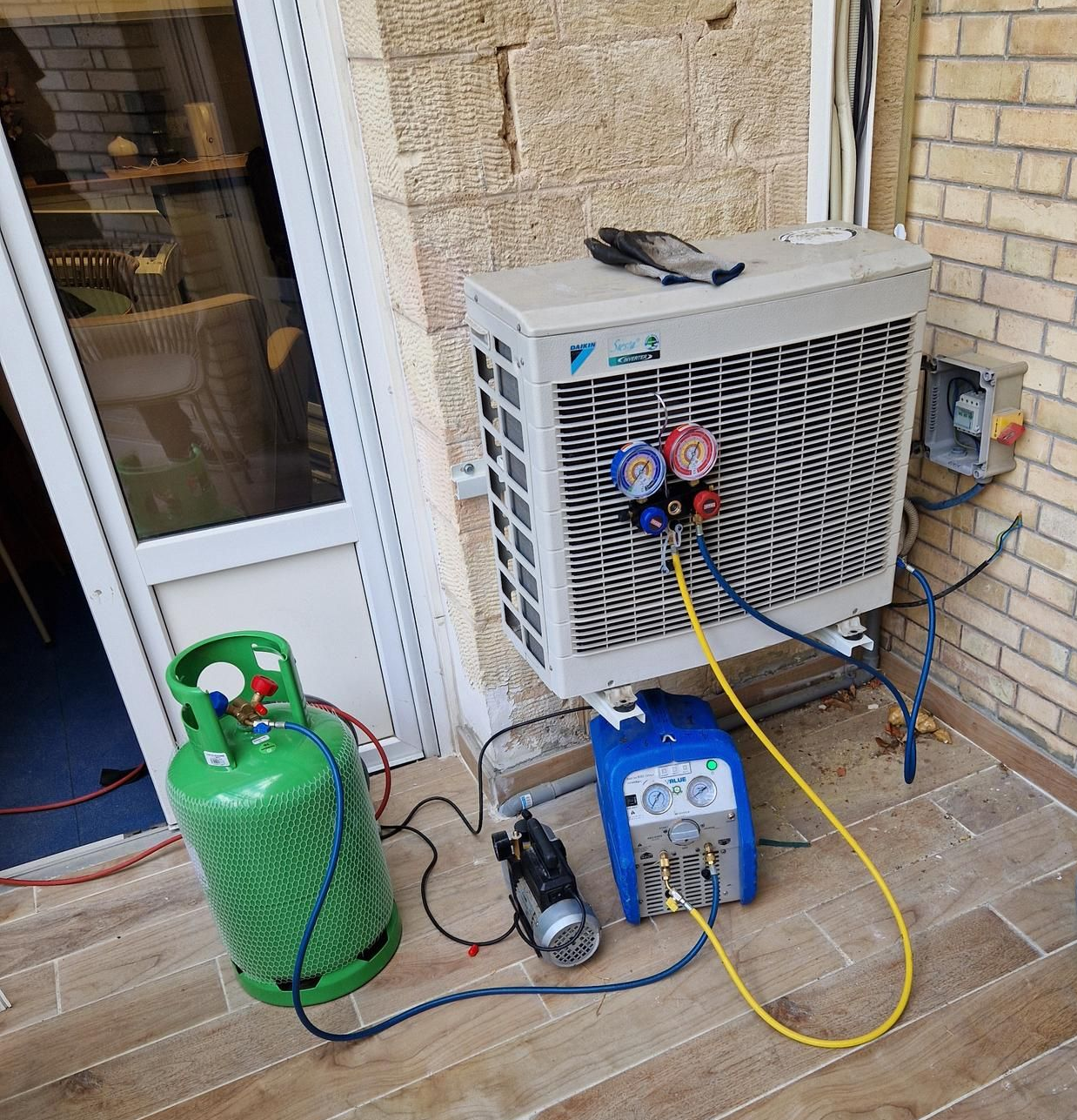 Unité de climatisation en cours d'entretien à l'extérieur, avec équipement raccordé et réservoir de réfrigérant.