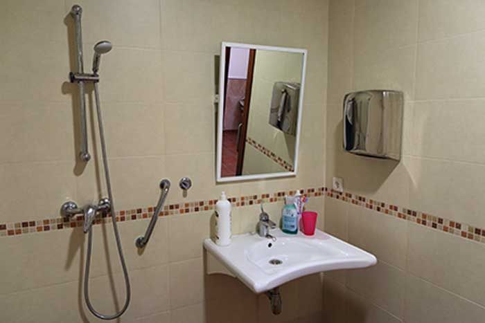 Un baño con lavabo, espejo y ducha.