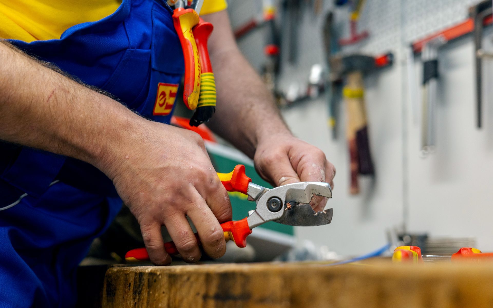 Ein Elektriker verwendet eine Zange, um einen Draht durchzuschneiden