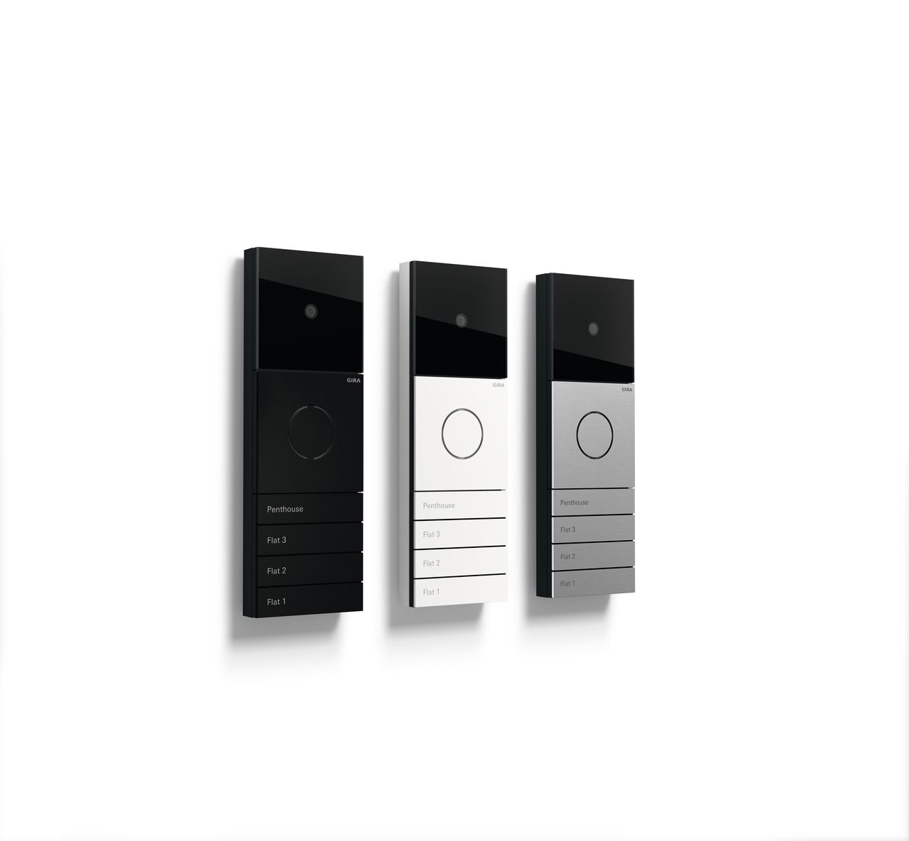 Drei elegante, moderne Türklingeln in Schwarz, Weiß und Silber, an einer weißen Wand montiert.