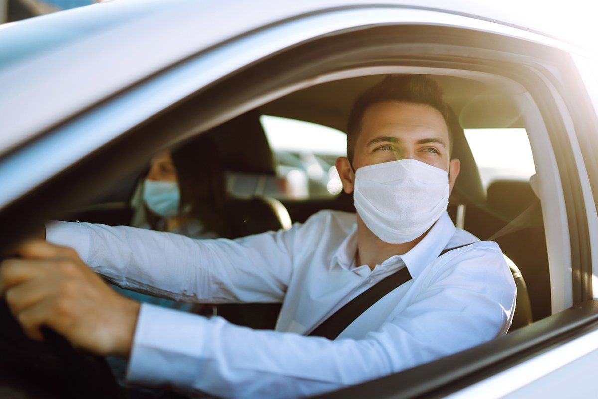 Homme portant un masque au volant de sa voiture avec passagère