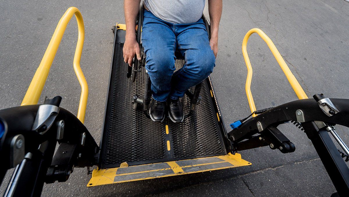 Homme en fauteuil roulant montant dans un véhicule ambulancier