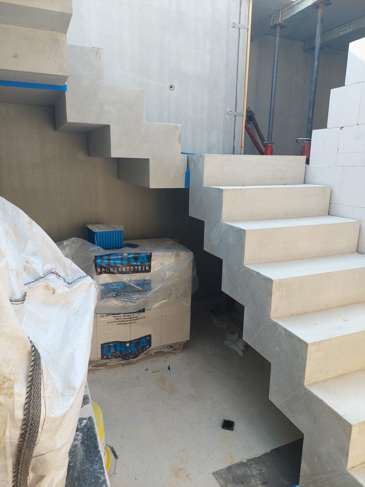 In einem Raum mit Kisten auf dem Boden wird eine Treppe gebaut.