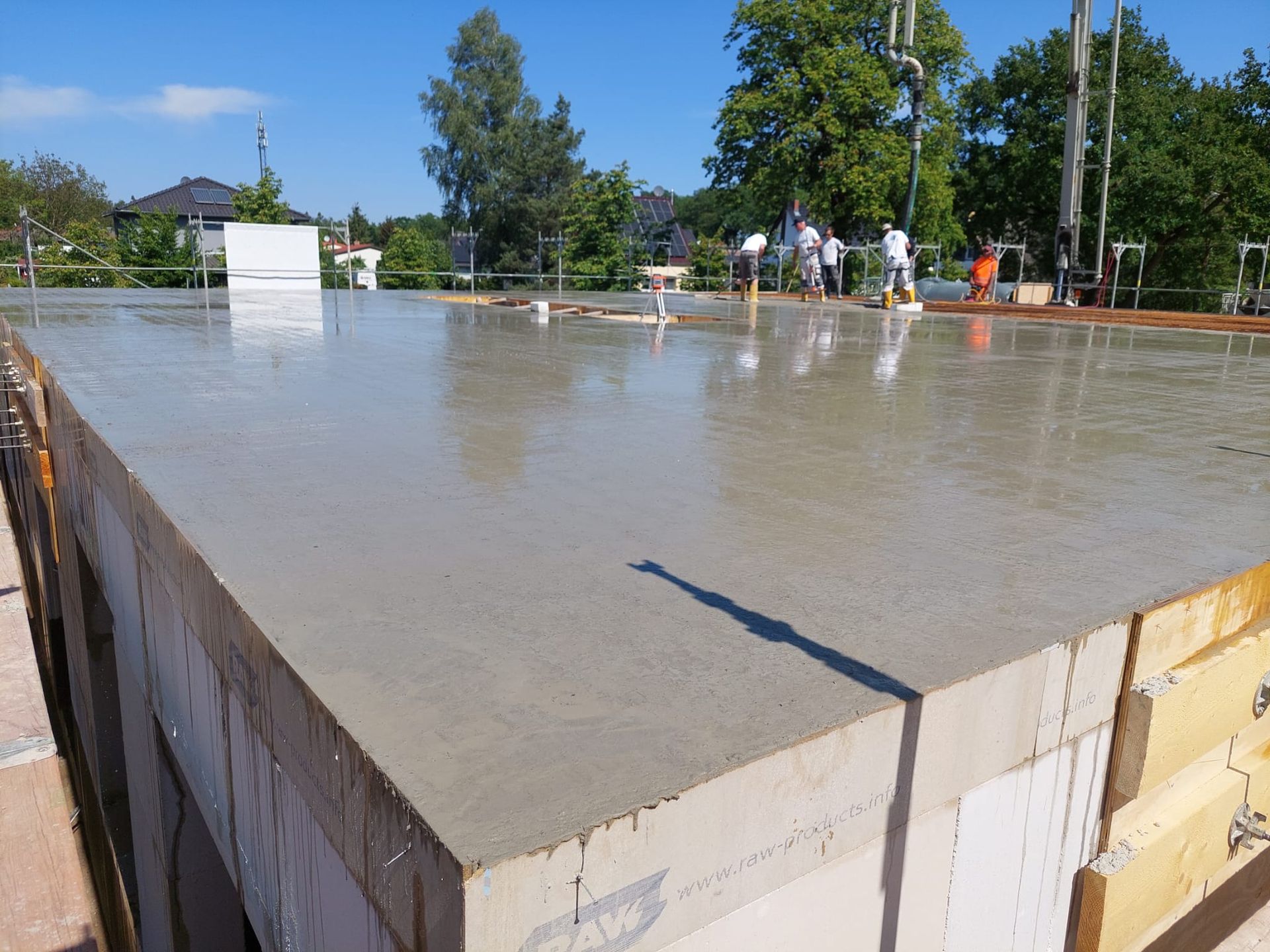 Eine Gruppe von Leuten arbeitet auf einem Betonboden.