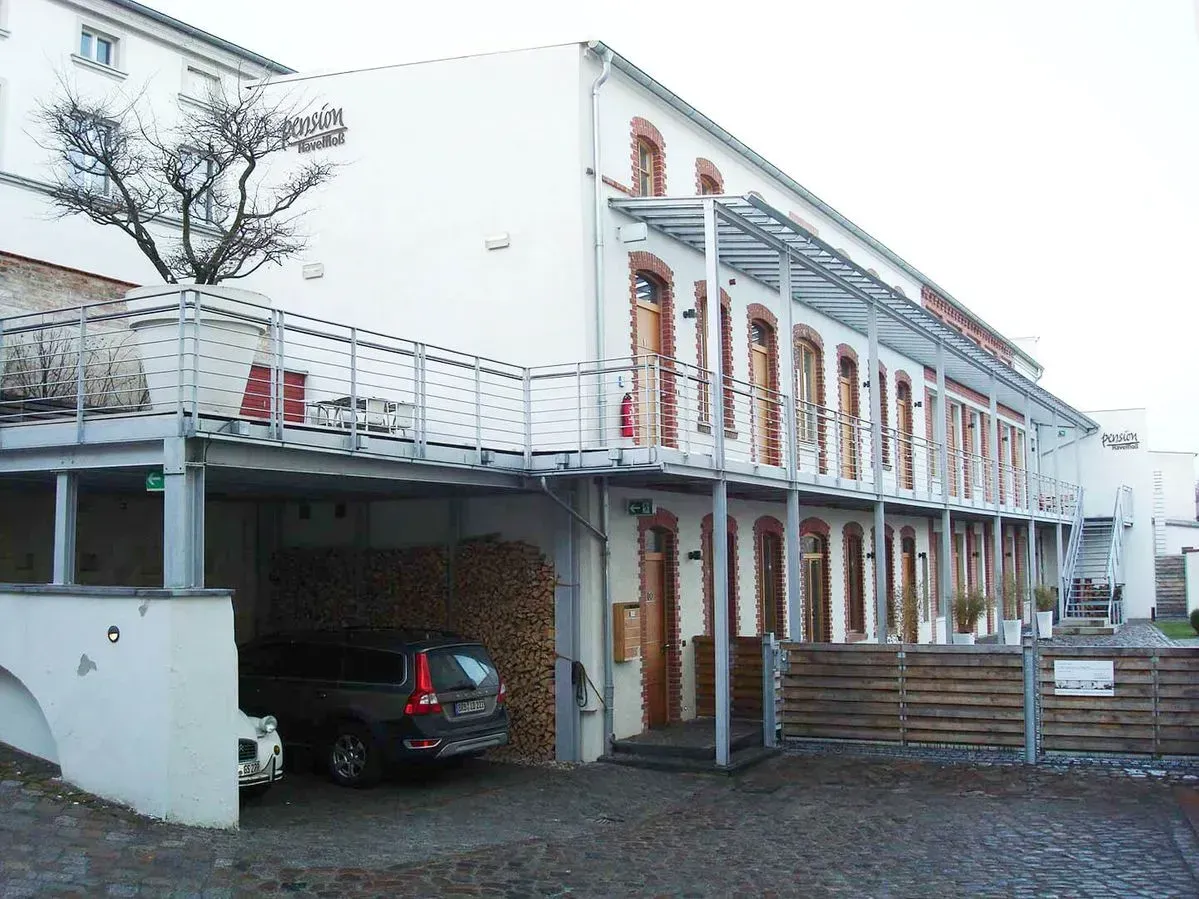 Ein weißes Gebäude mit einem darunter geparkten Auto