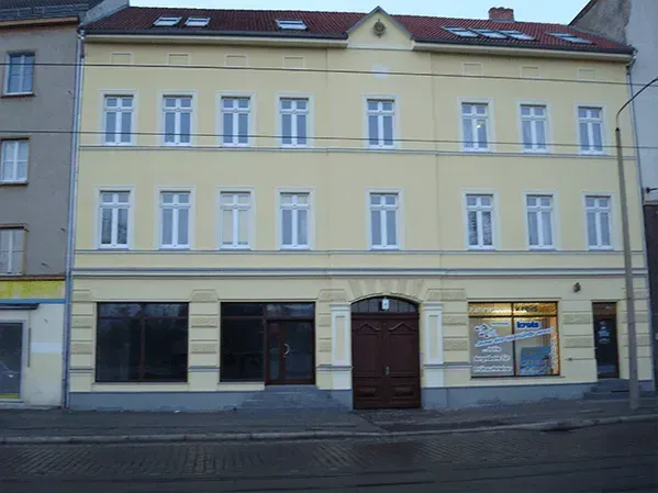 Ein großes gelbes Gebäude mit einem roten Dach