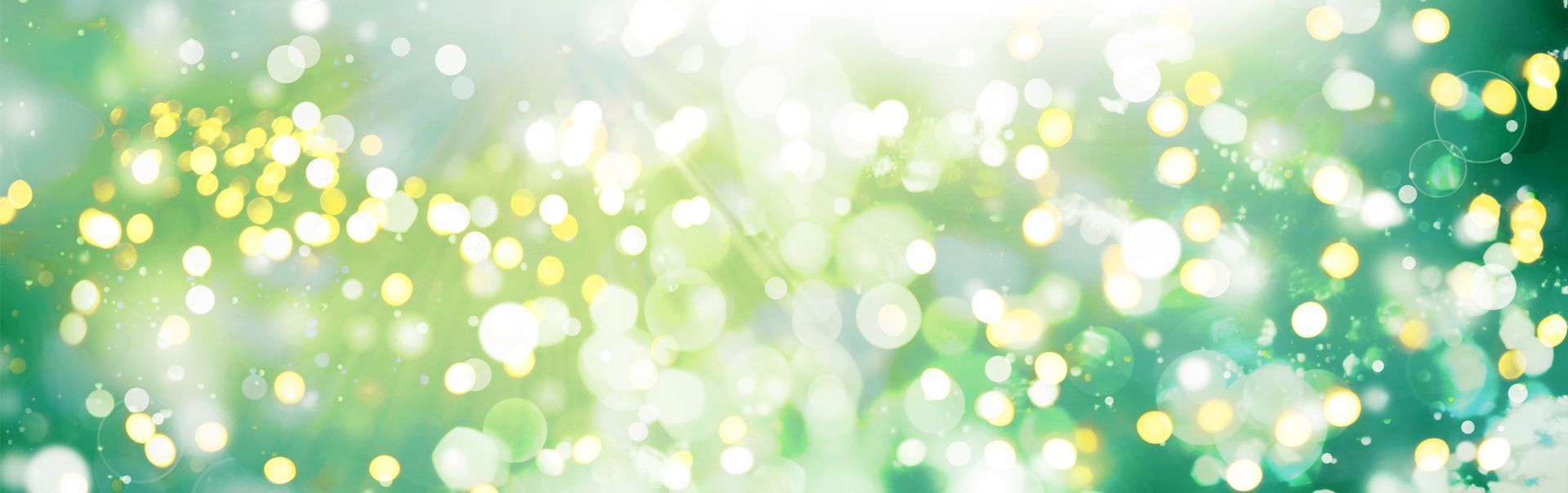 Grüner und gelber Bokeh-Hintergrund mit sanften Lichtreflexen.