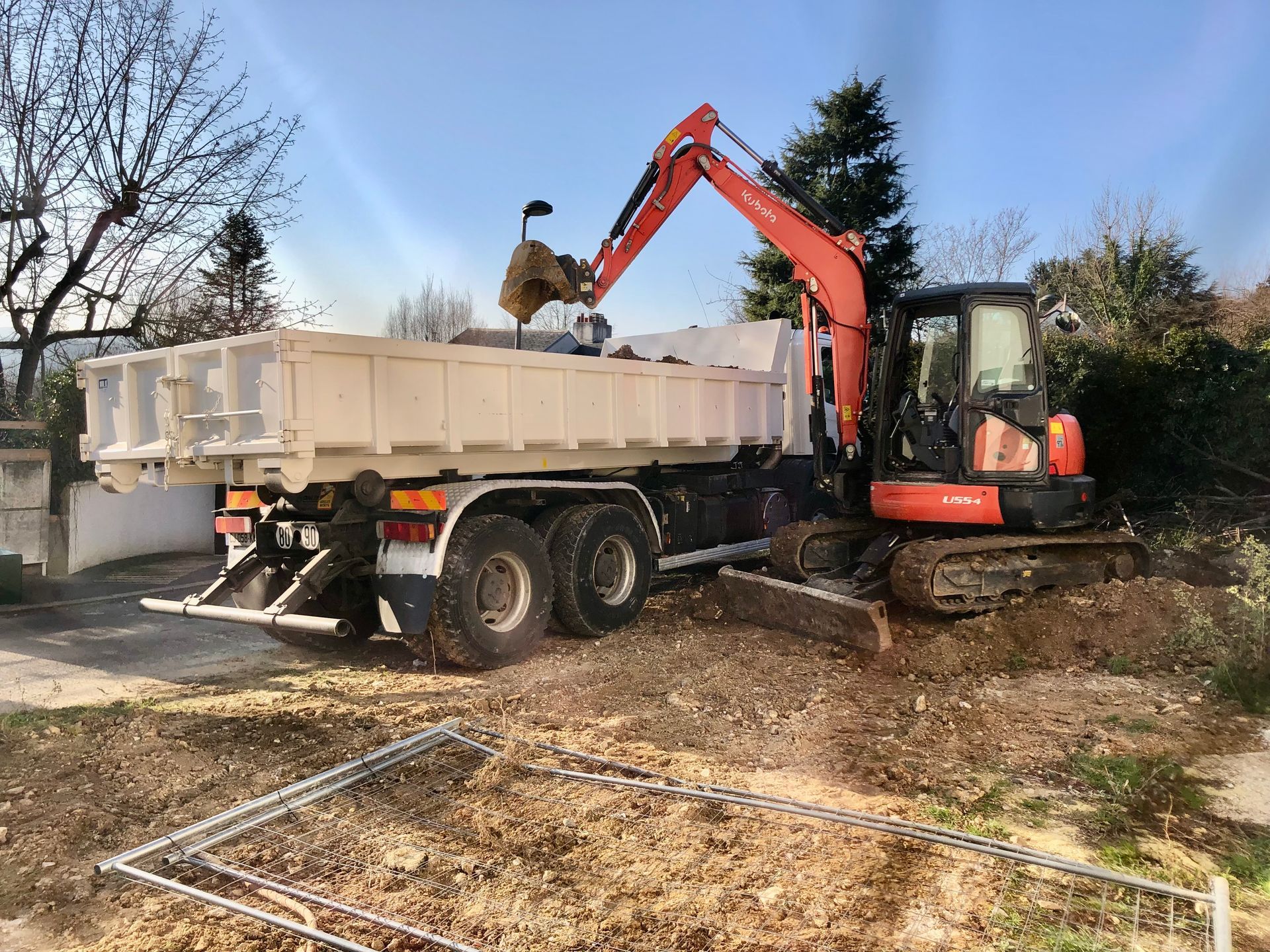 Une pelle orange qui remplit un camion-benne