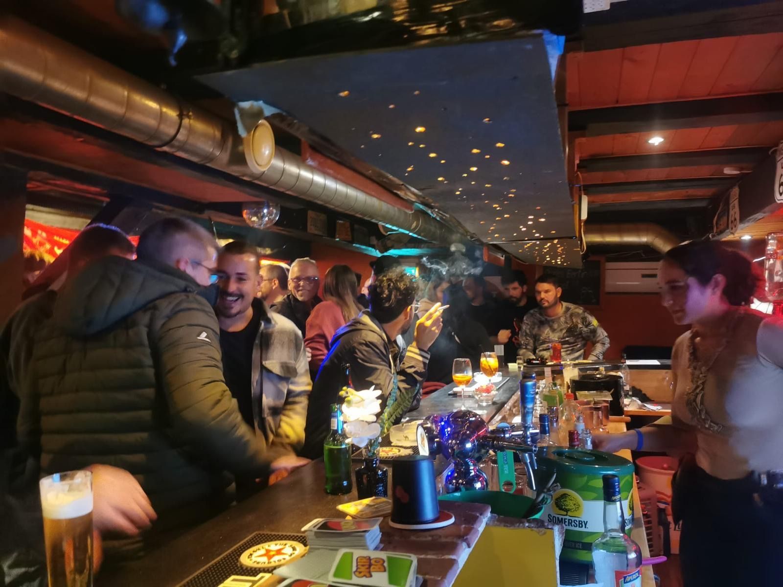 Aussenterrasse eines Cafés mit weissen Tischen und Stühlen neben einem Gebäude an einer sonnigen Strasse