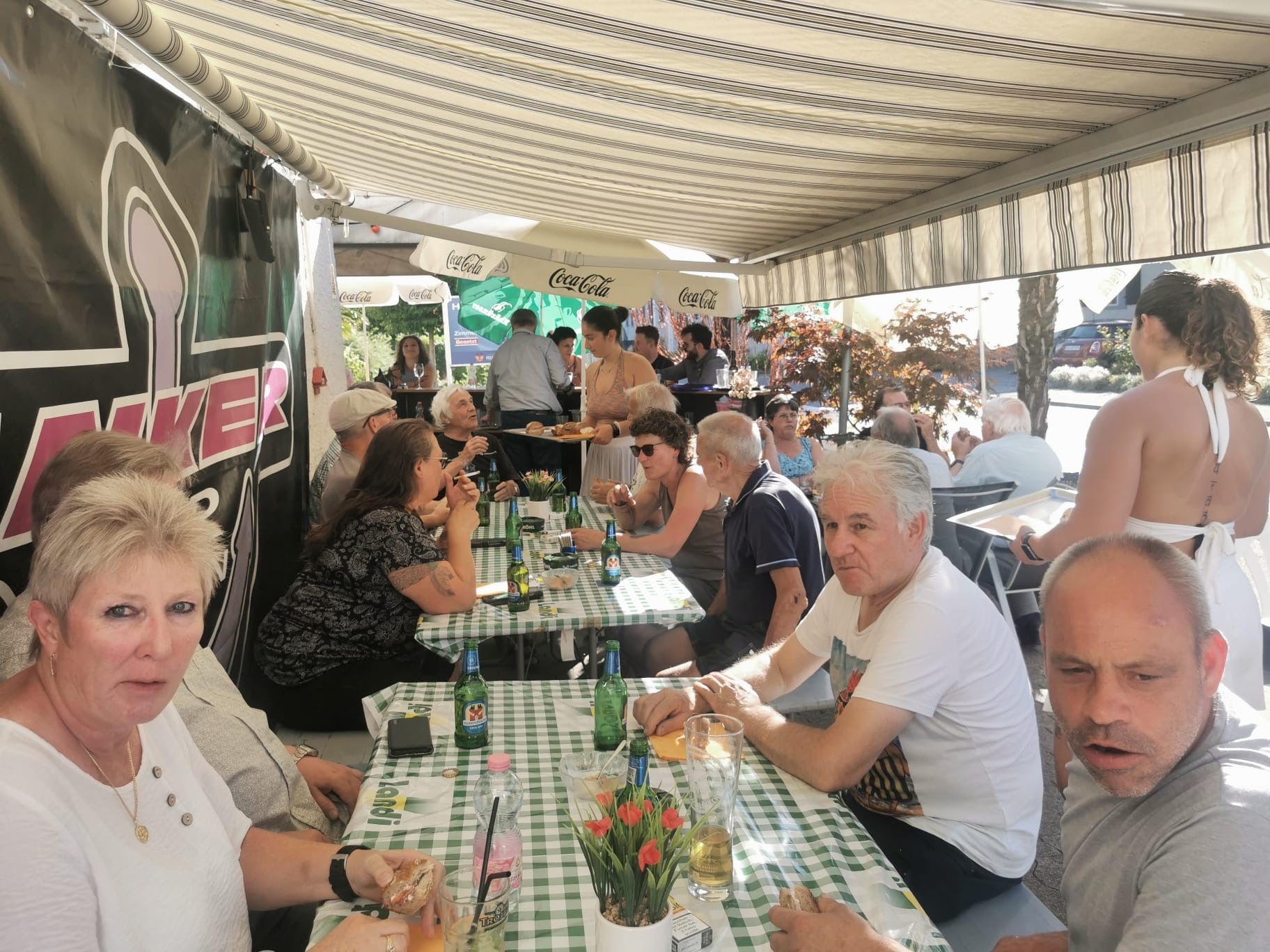 Holzvertäfelte Bar mit Barhockern, gerahmten Fotos und einer langen Holztheke.