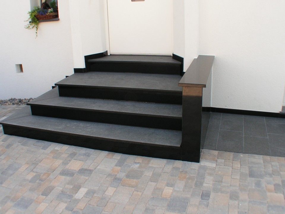 dunkle Fliesen auf einer Treppe vor einer Haustür
