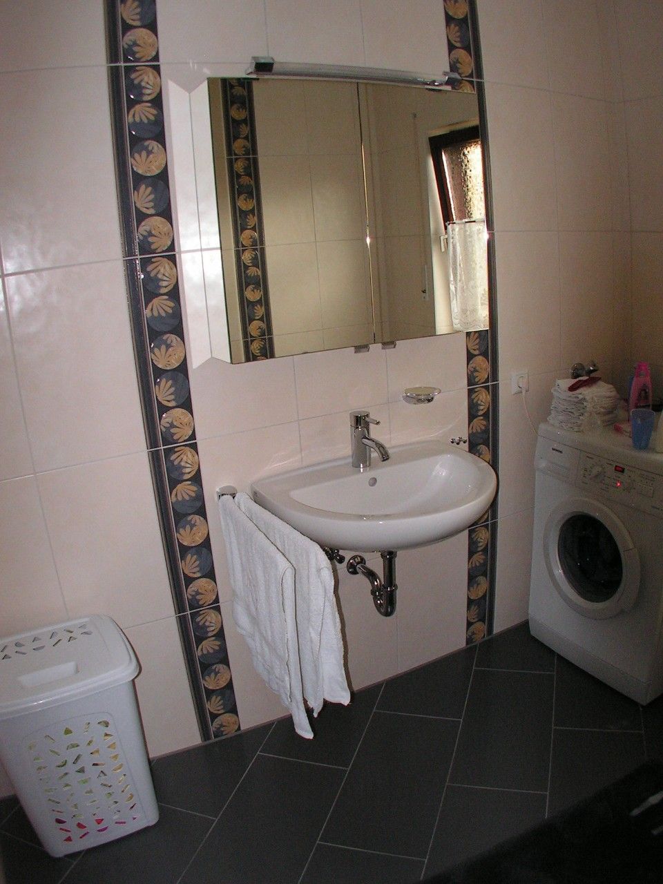 weiße Fliesen im Badezimmer und eine Waschmaschine