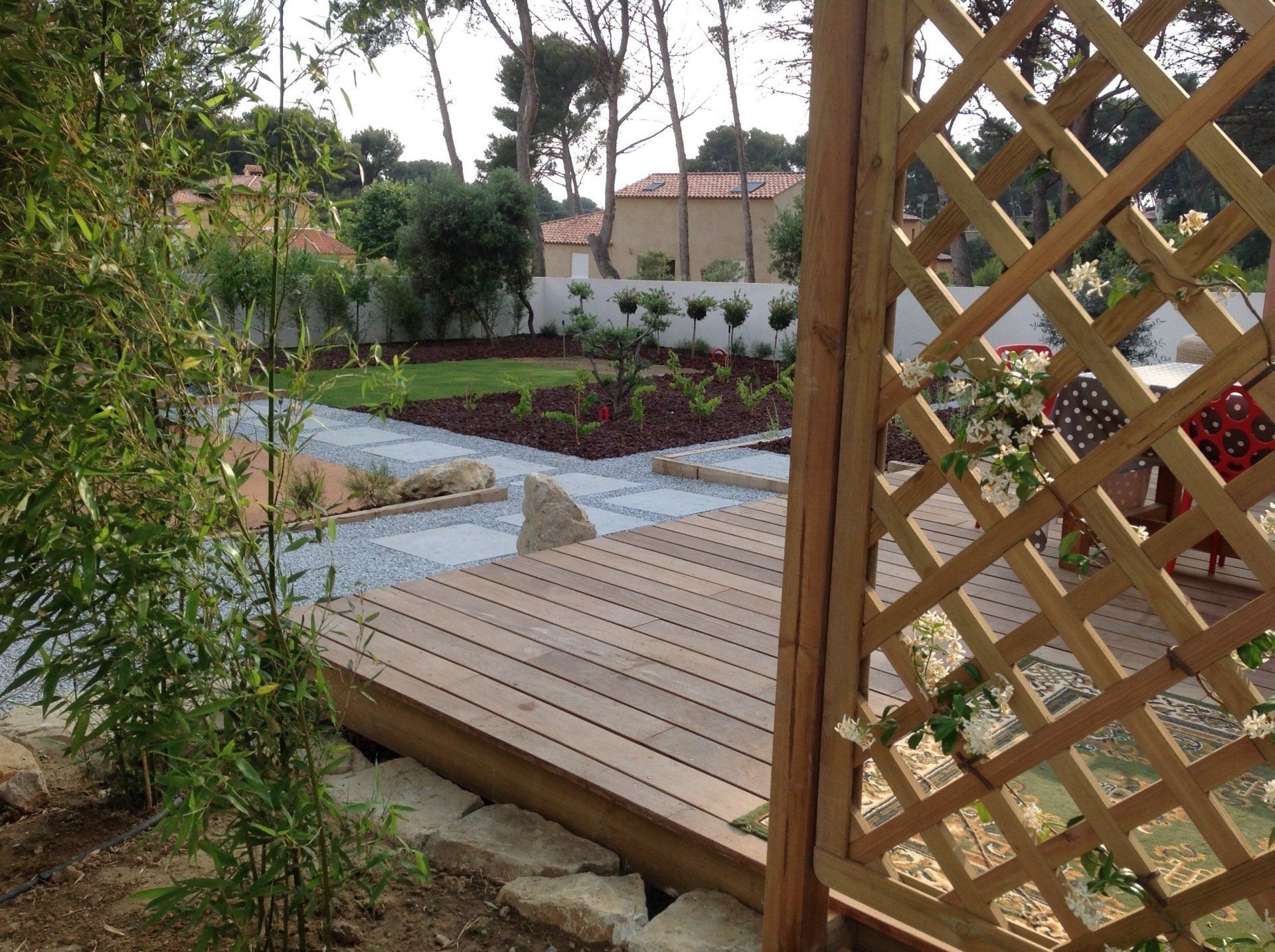 Jardin méditerranéen avec palissade en bois au premier plan