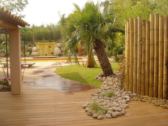 Jardin tropical avec terrasse et galets