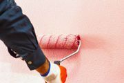 Una persona está pintando una pared con un rodillo de pintura.