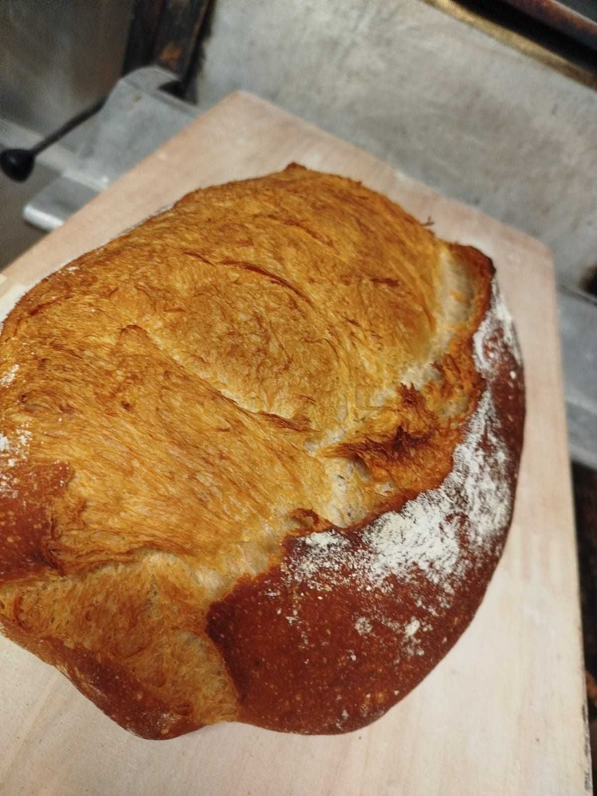 Una hogaza de pan artesanal de color marrón dorado, con una corteza crujiente y marcada.