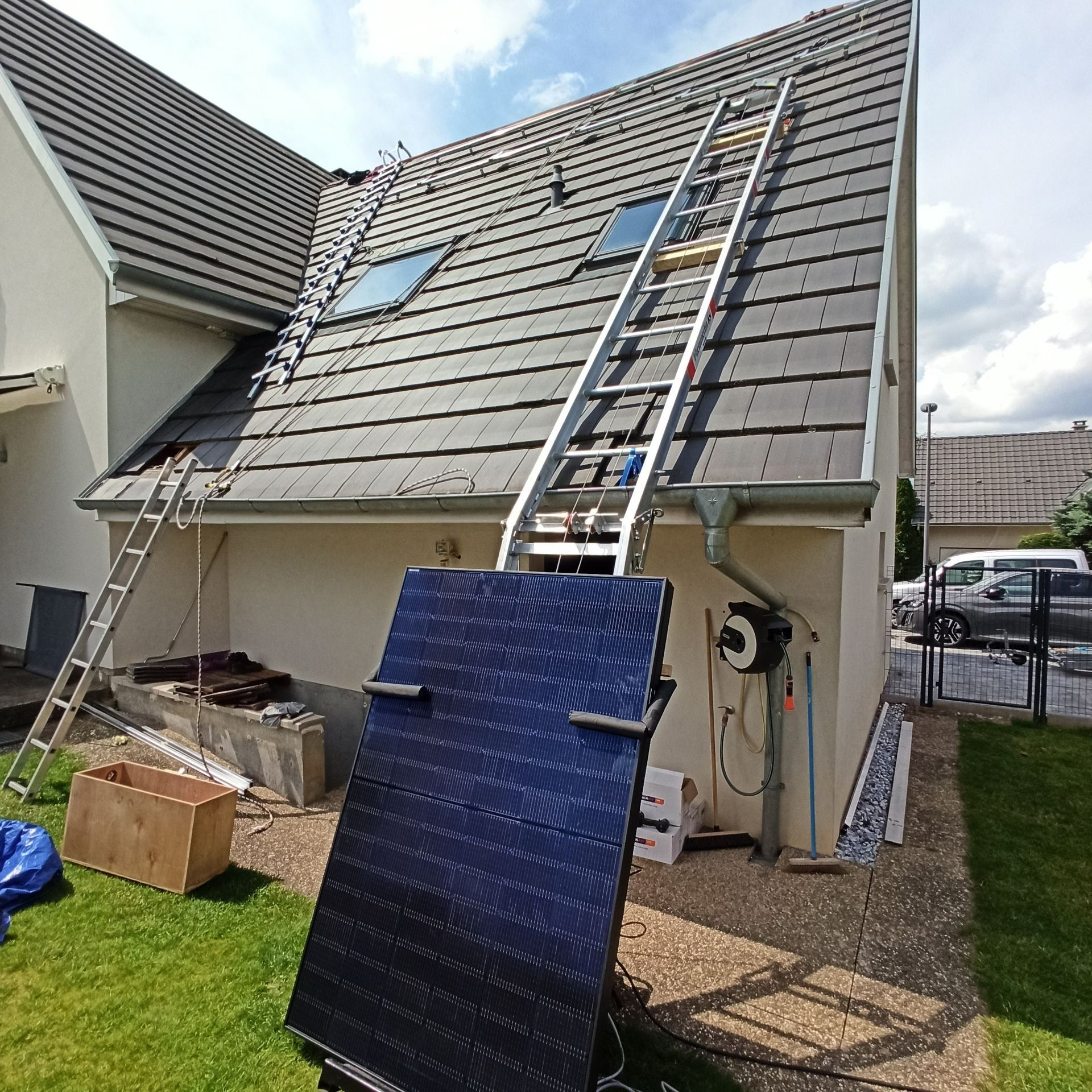 Panneau photovoltaïque appuyé contre une maison, avec des échelles.