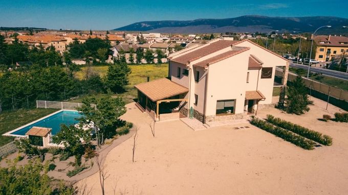 Una vista aérea de una casa grande con piscina en el patio trasero.