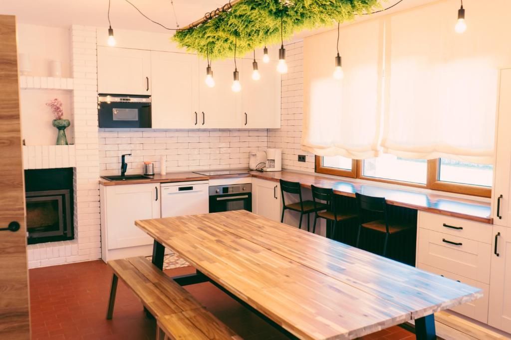 Una cocina con una larga mesa de madera y bancos.