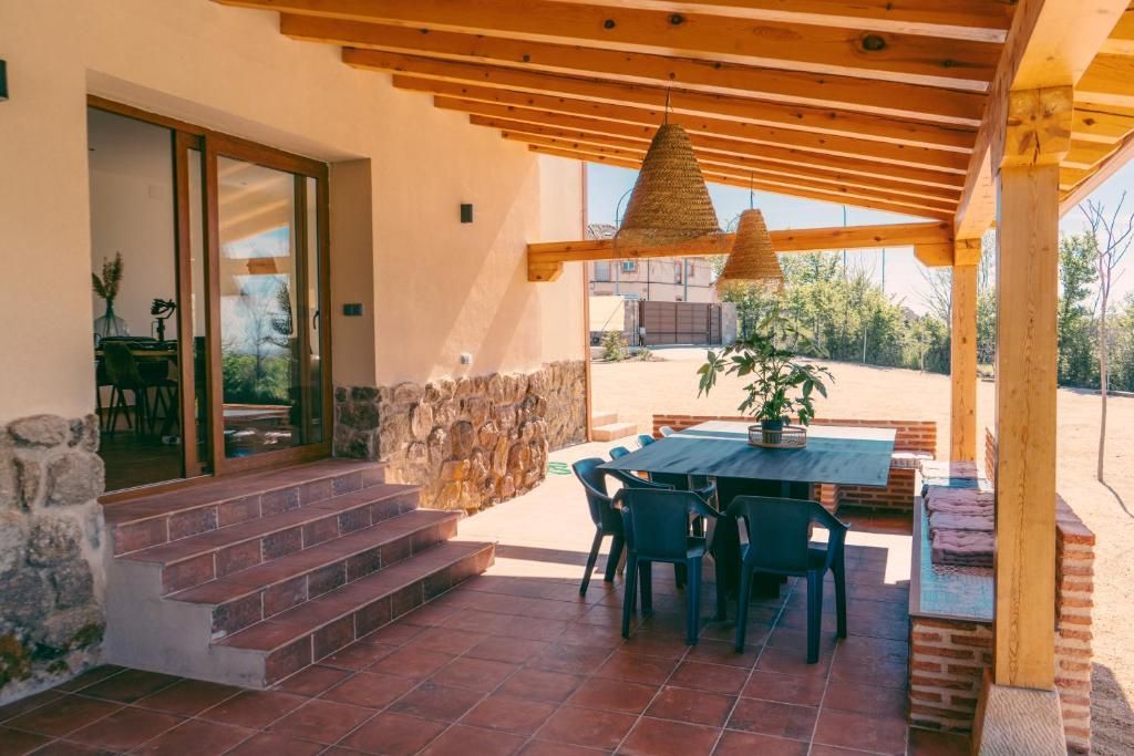 Un patio con mesa y sillas bajo un techo de madera.